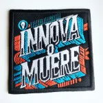 Parche con frase de innova o muere bordado en colores celeste, rojo y blanco